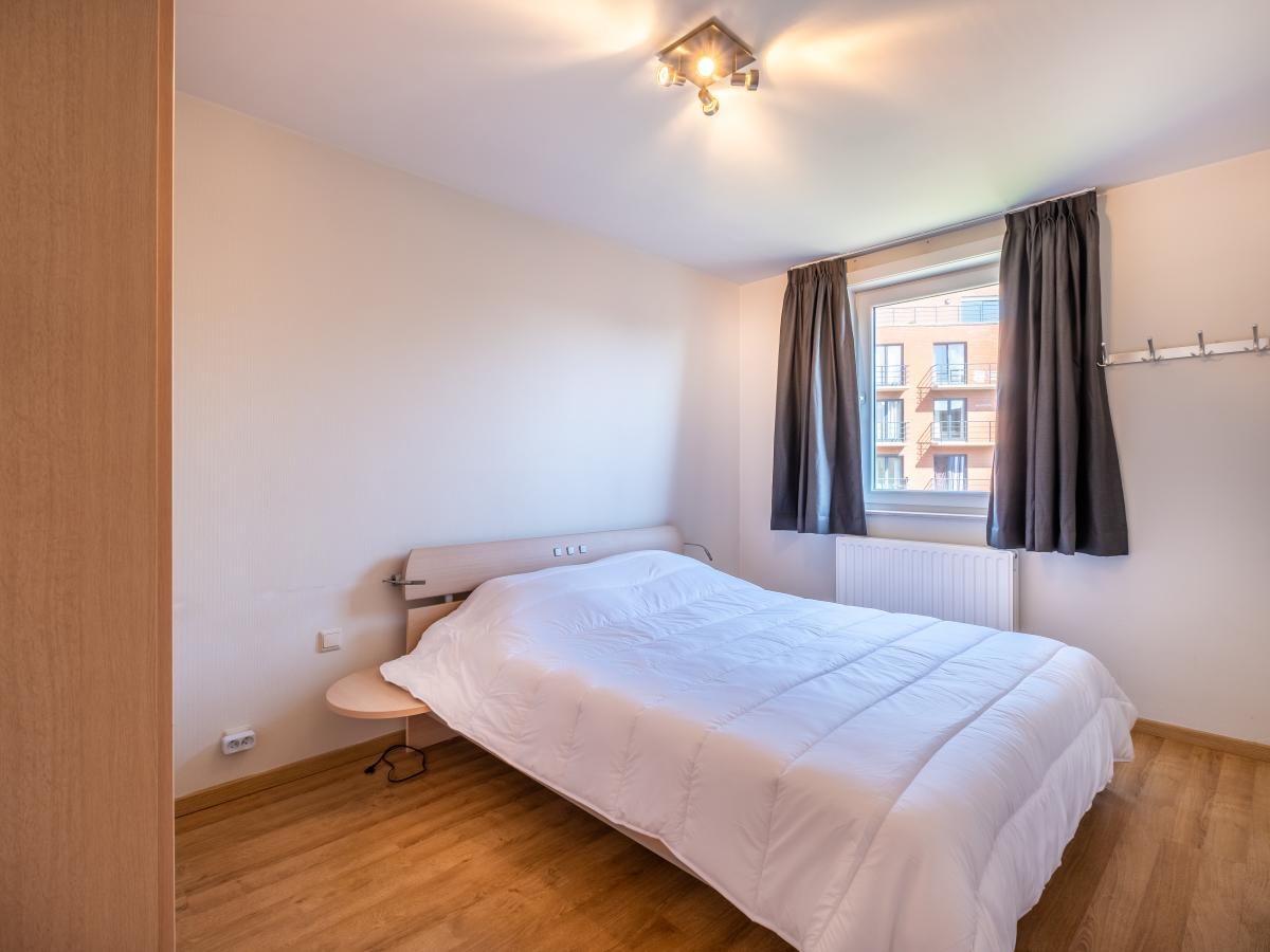 Gezellige slaapkamer in vakantiehuis Paco Vierde, Koksijde, West-Vlaanderen, met comfortabel bed en natuurlijk licht door het raam.