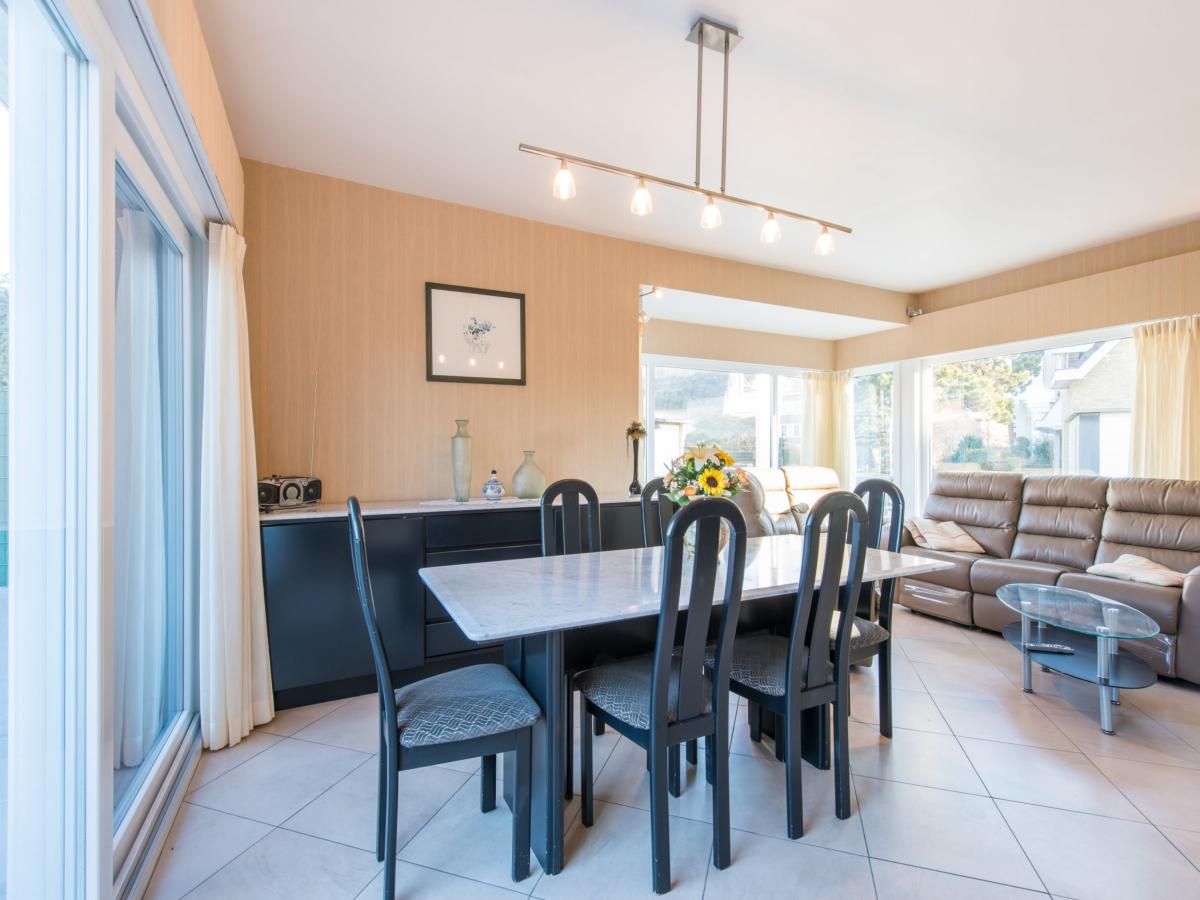 Gezellige eetkamer in vakantiehuis Mallory, Koksijde, met veel natuurlijk licht en comfortabele zithoek in West-Vlaanderen, Belgie.