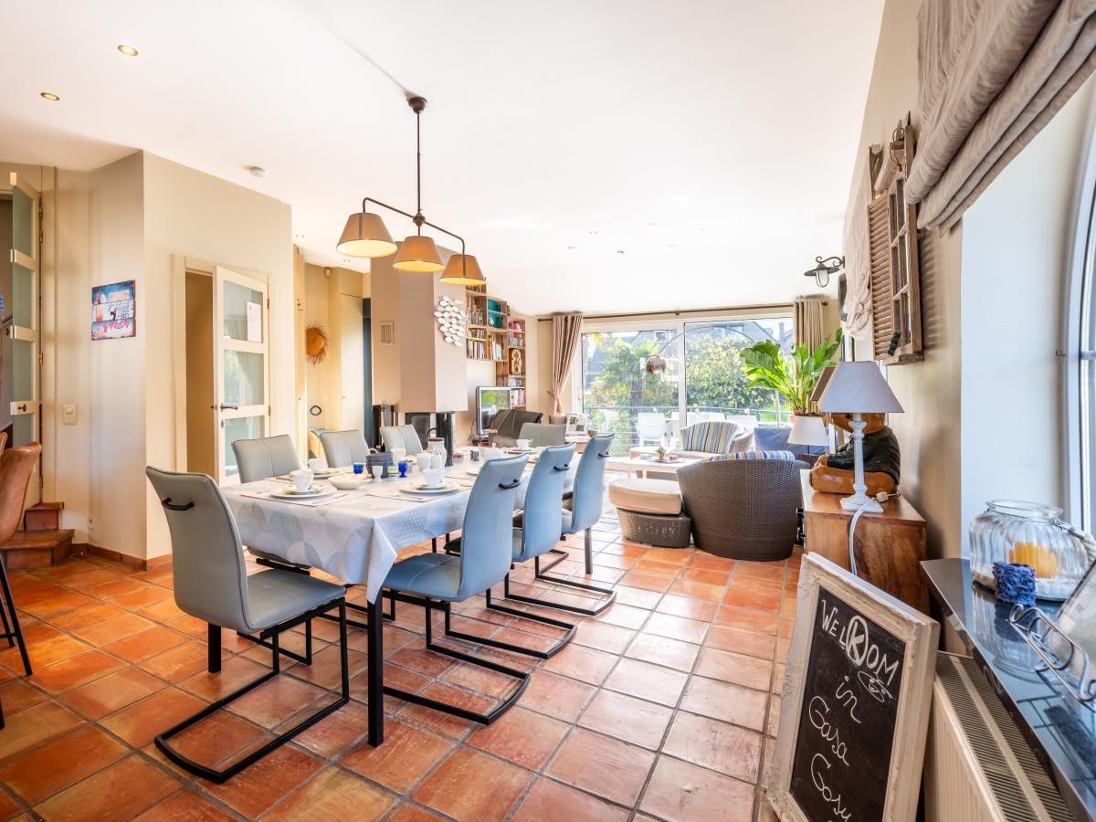Ruime eetkamer in vakantiehuis Le Palmier in Koksijde, West-Vlaanderen, met uitzicht op tuin en comfortabele inrichting.