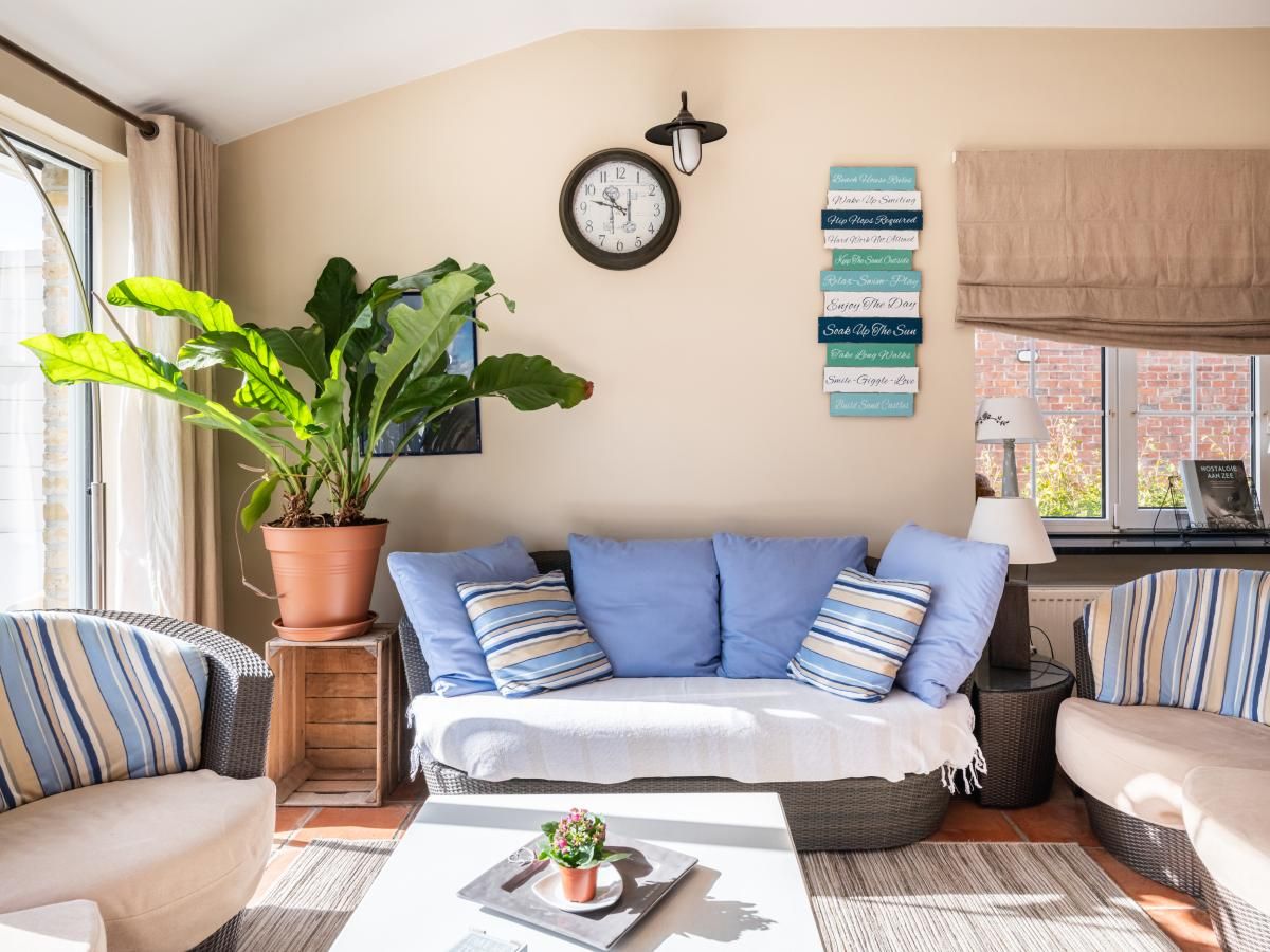 Gezellige woonkamer in vakantiehuis Le Palmier in Koksijde, West-Vlaanderen, met comfortabele zithoek en veel natuurlijk licht.