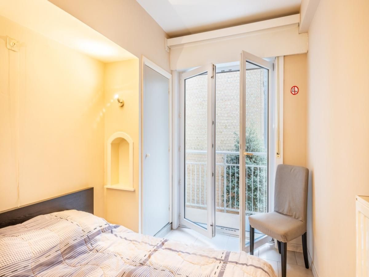 Slaapkamer in vakantiehuis Vitelli in Koksijde, West-Vlaanderen met balkon en natuurlijk licht.