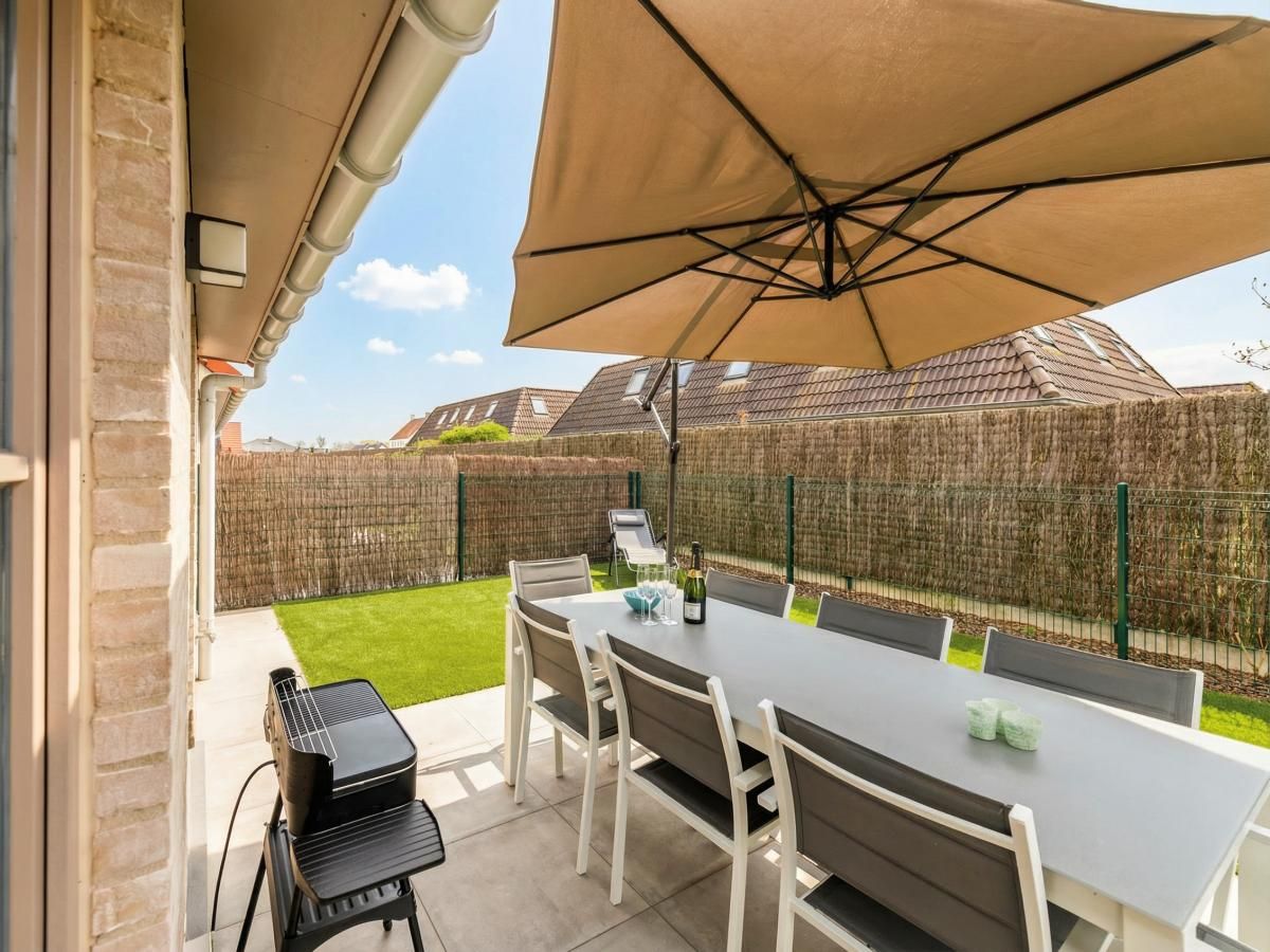 Moderne keuken en eetruimte in vakantiehuis Westhinder I H12, Koksijde, met houten balken en veel lichtinval.