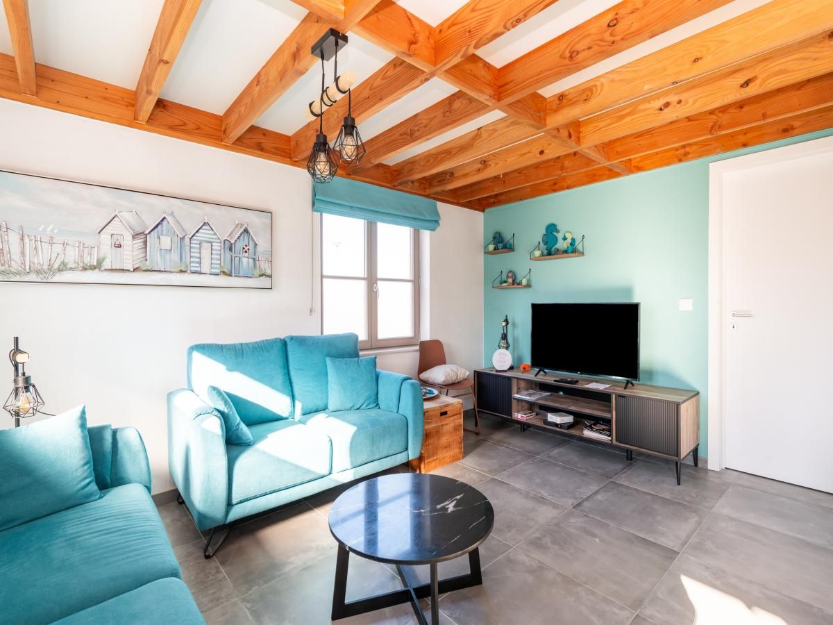 Gezellige woonkamer in vakantiehuis Westhinder I H12, Koksijde, met houten balkenplafond en moderne inrichting, West-Vlaanderen, Belgie.