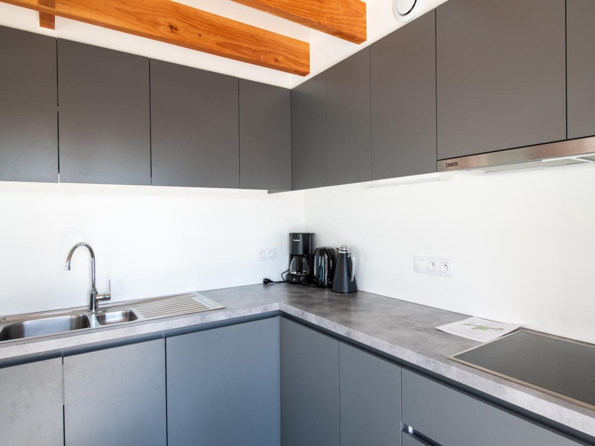 Gezellige woonkamer van vakantiehuis Westhinder I H12 in Koksijde, West-Vlaanderen, met moderne inrichting en houten balkenplafond.