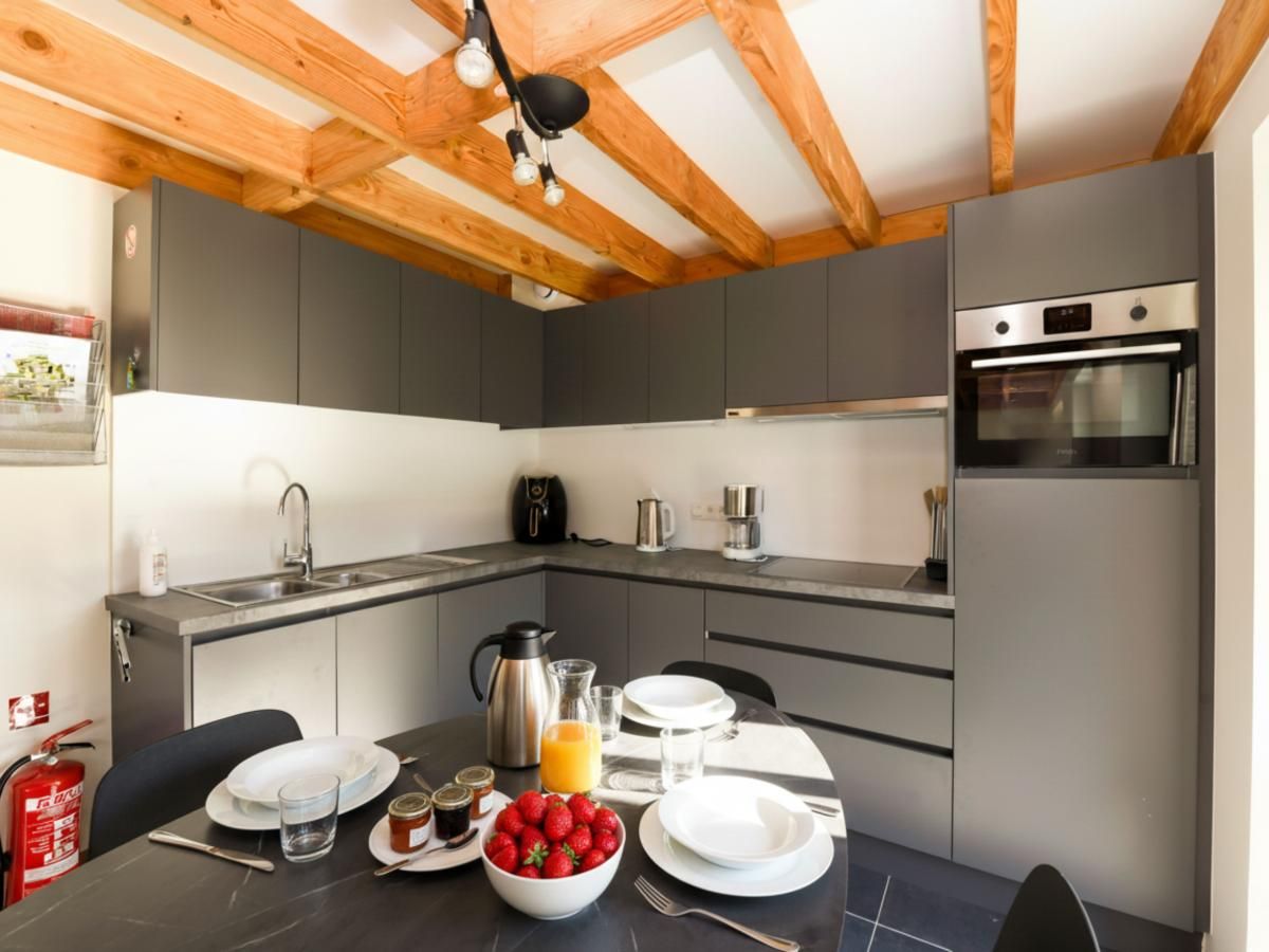 Moderne Kueche im Ferienhaus Westhinder II H53, Koksijde, Westflandern, mit Holzbalken und stilvoller Einrichtung.