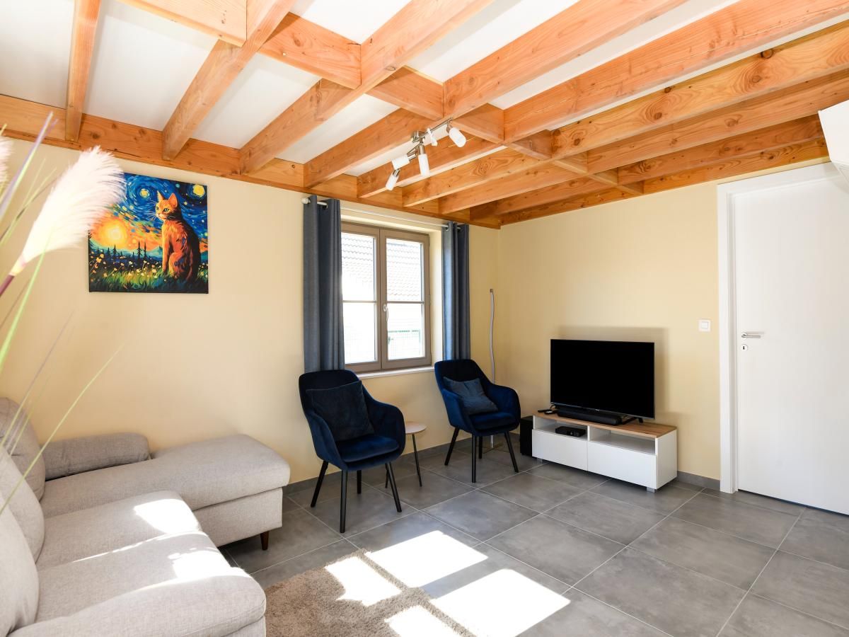 Gezellige woonkamer in vakantiehuis Westhinder II H54, Koksijde, Belgie met comfortabele zithoek en moderne inrichting.