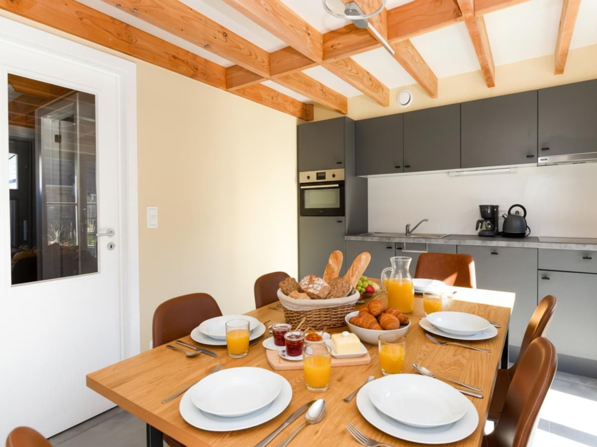 Gezellige eetruimte in vakantiehuis Westhinder II H54 in Koksijde, West-Vlaanderen, met moderne keuken en uitnodigende ontbijttafel.