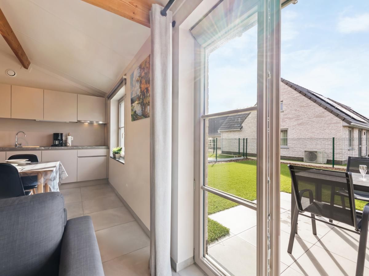 Moderne keuken en eetruimte in vakantiehuis Westhinder II H18, Koksijde, West-Vlaanderen, met veel lichtinval en stijlvolle inrichting.