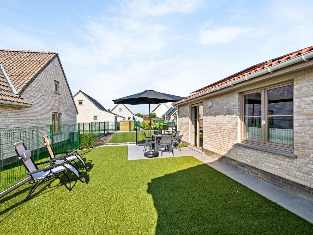 Gemuetliches Wohnzimmer des Ferienhauses Westhinder II H19 in Koksijde, Westflandern, mit bequemem Sofa und rustikalen Moebeln.