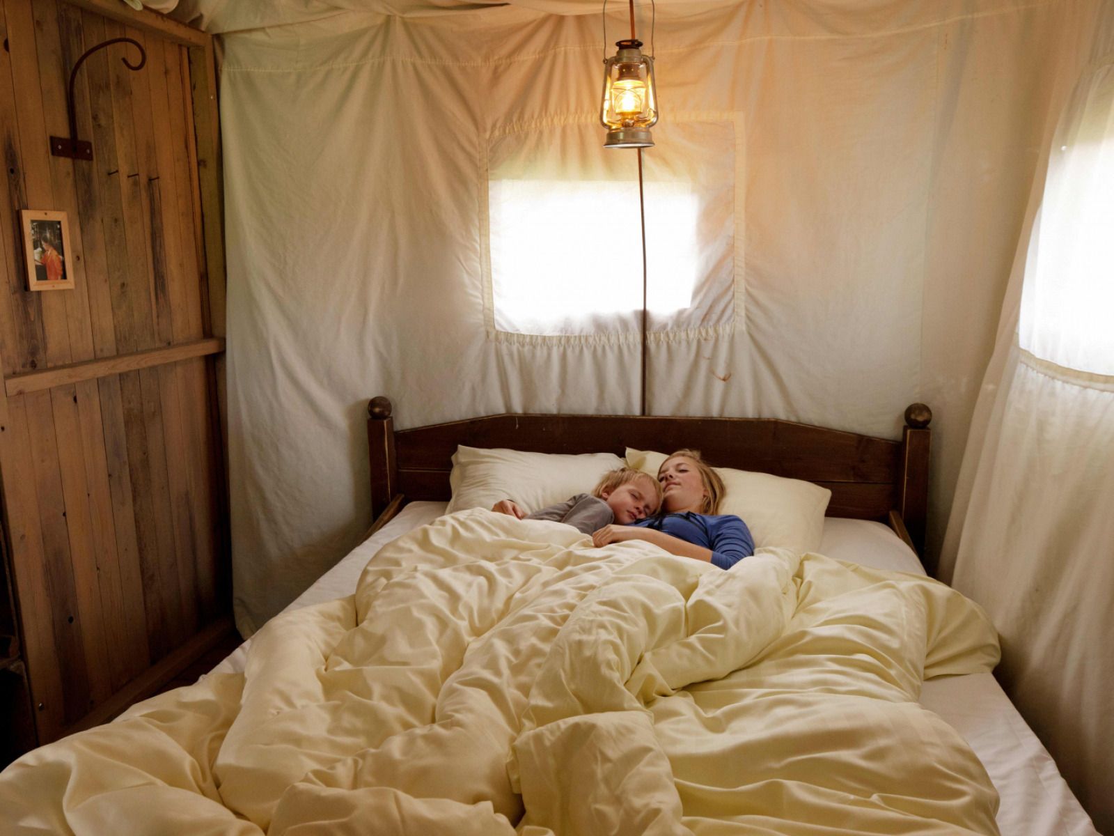 Gemuetliches Schlafzimmer in der Tent Lodge mit privater Warmwasserdusche, Poperinge, Belgien. Bequemes Bett in gemuetlicher Glamping Lodge.