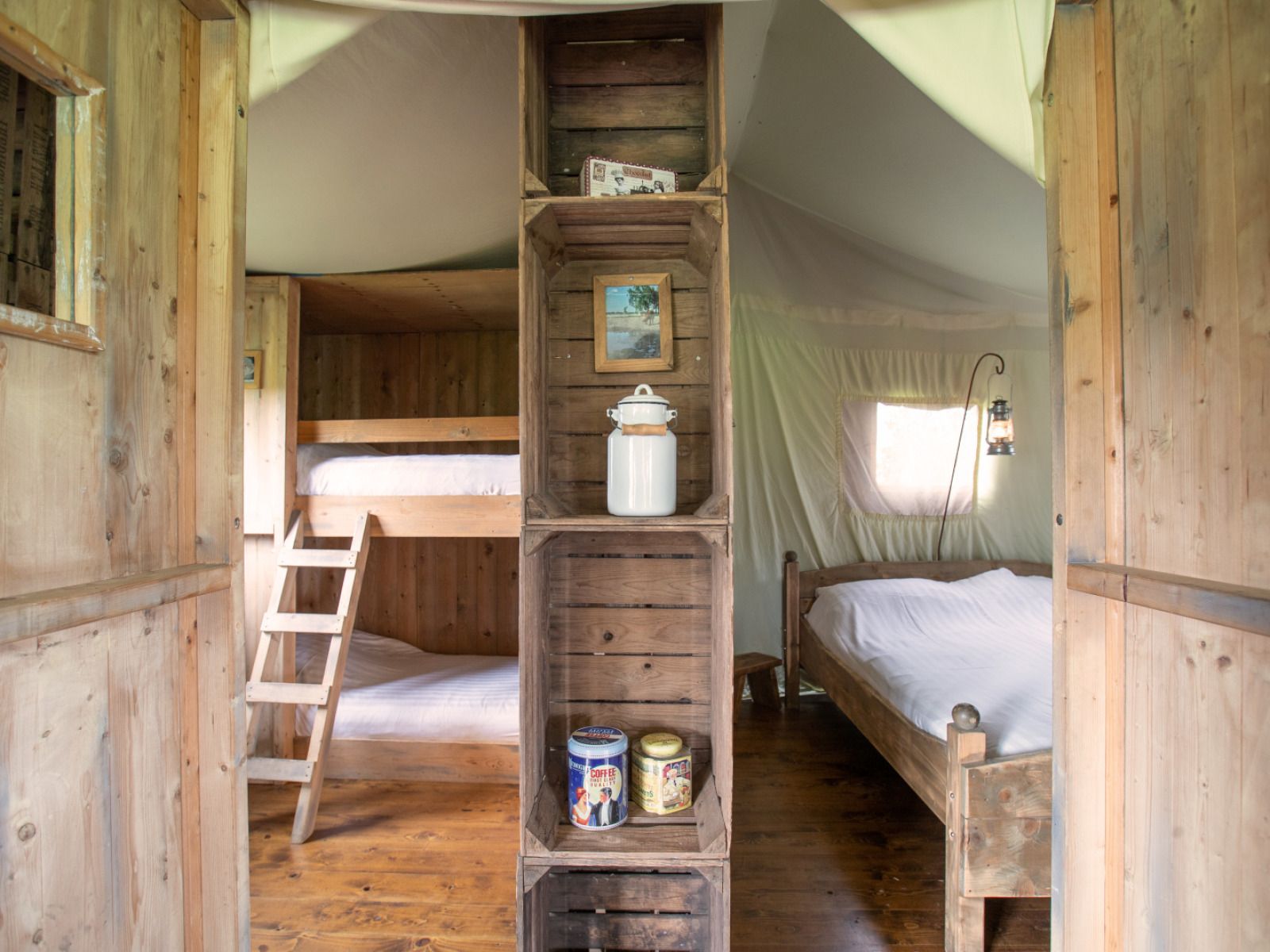 Gemuetliches Zeltcottage mit eigener Warmwasserdusche in Poperinge, Westflandern, Belgien, mit rustikalen Holzmoebeln.