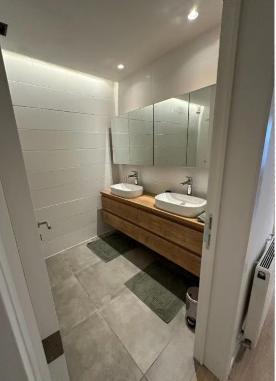 Moderne Kueche in der Wohnung Memling, Sint-Andries, Westflandern, mit schlichtem Design und attraktiver Backsteinwand.