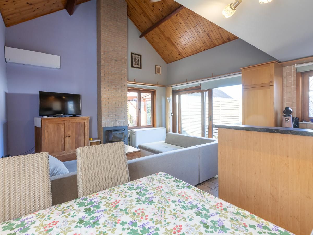 Gezellige woonruimte in vakantiehuis Wittedorp - 15, Lombardsijde, met houten plafond en ruime zithoek in West-Vlaanderen, Belgie.