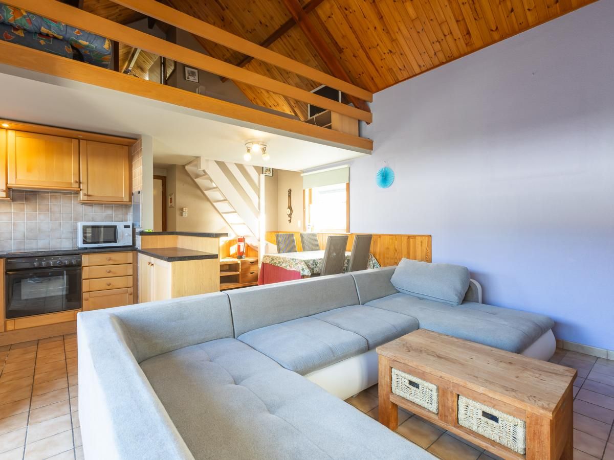 Gezellige woonkamer in vakantiehuis Wittedorp - 15, Lombardsijde, West-Vlaanderen met houten interieur en comfortabele zithoek.