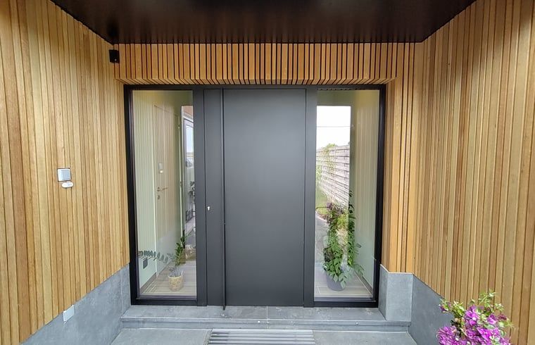Schlichter und moderner Eingang des Ferienhauses in Ingooigem, Westflandern, mit Holzverkleidung.