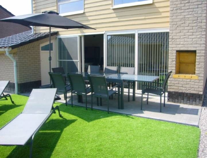 Veranda des Ferienhauses Lombardsijde in Lombardsijde-Middelkerke, Westflandern, Belgien mit bequemen Stuehlen.