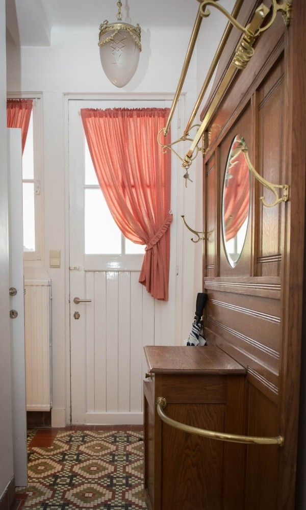 Ontvangstruimte van Charmevilla Westende, een vakantiehuis in Westende, Belgie, met vintage houten meubels en kleurrijke tegels.