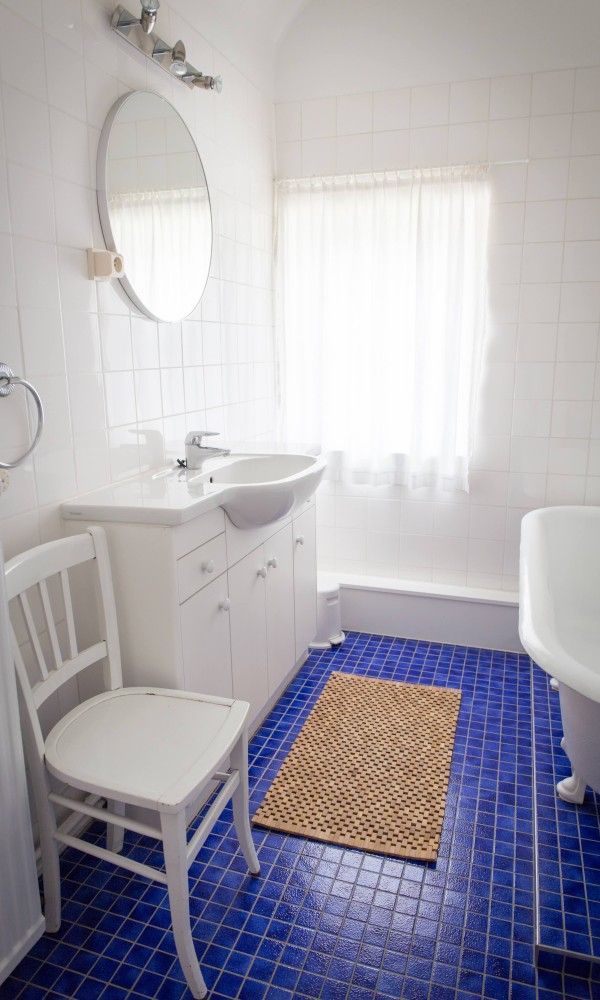 Stijlvolle badkamer in Charmevilla Westende vakantiehuis, Westende, Belgie. Helder interieur met blauwe tegels en klassieke inrichting.