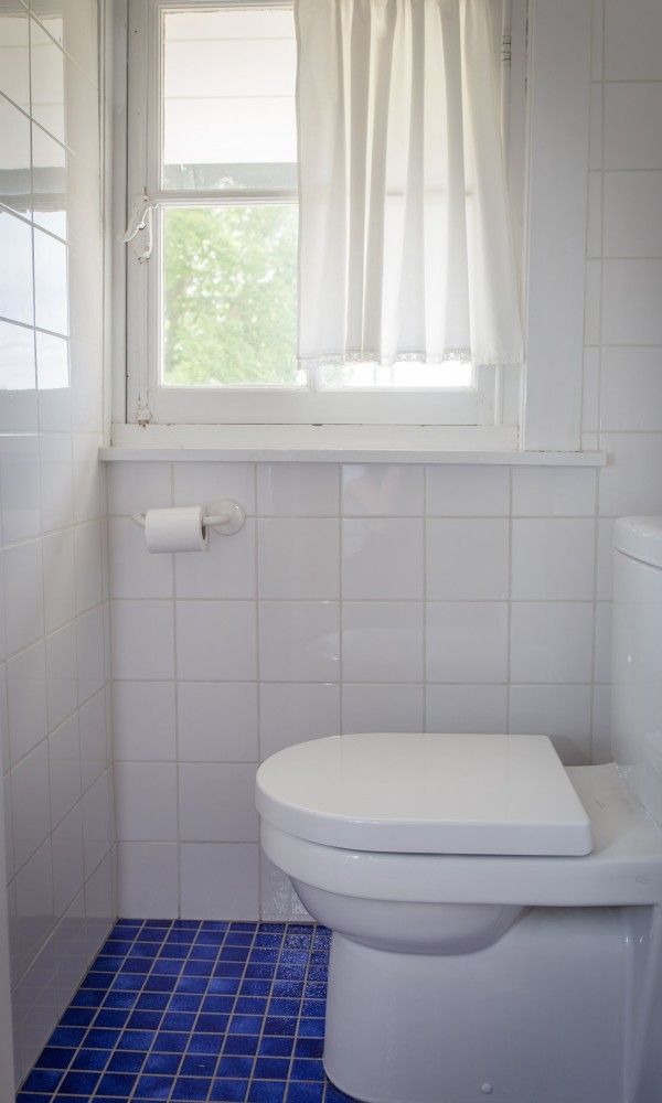 Moderne badkamer in Charmevilla Westende, vakantiehuis in Westende, Belgie, met helder verlichte tegelvloer en raam voor natuurlijk licht.