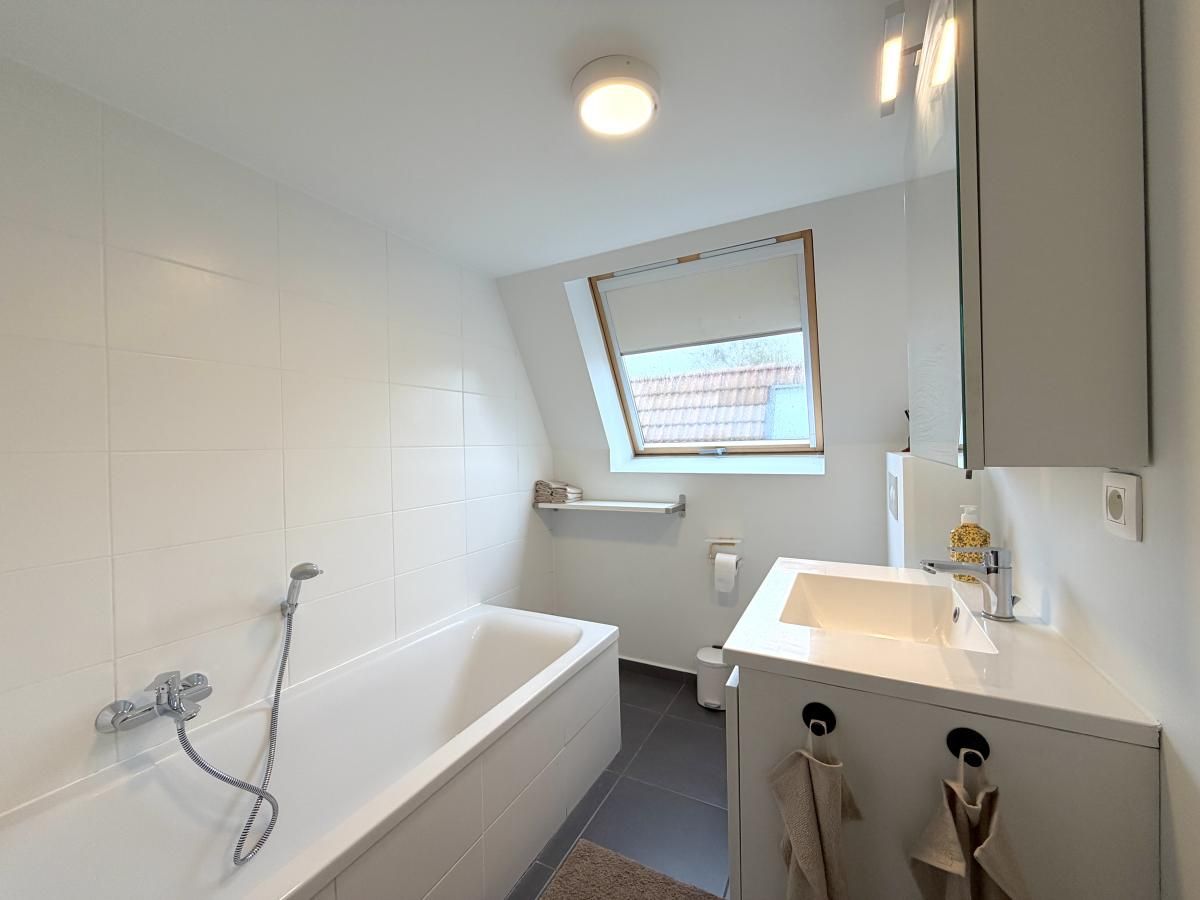 Modernes Badezimmer des Home Sweet Home Ferienhauses in De Panne, Westflandern, mit Badewanne und Tageslicht.
