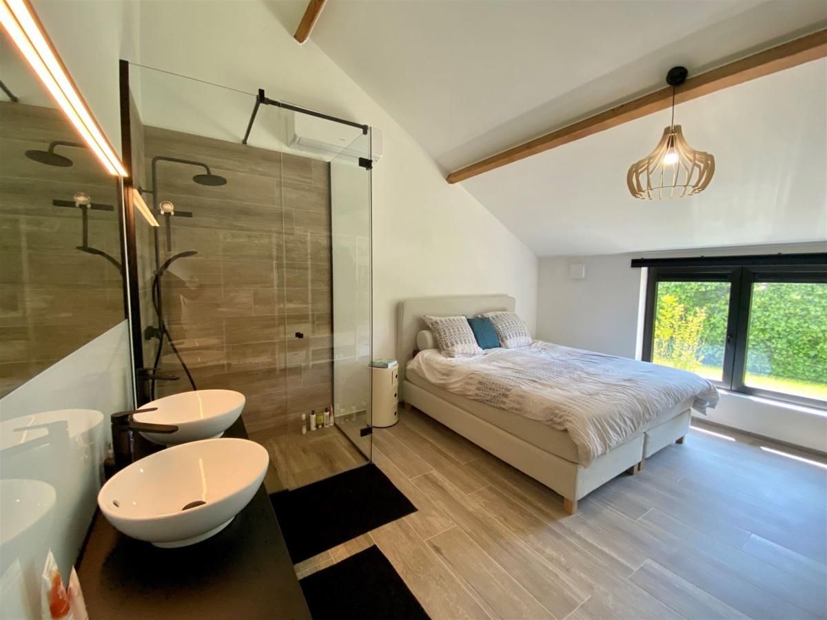 Luxurioeses Schlafzimmer im Ferienhaus Petunias Deluxe, Sint-Idesbald, Westflandern, mit moderner Einrichtung und Gartenblick.