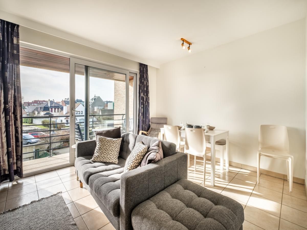 Lichte woonkamer van vakantiehuis Cat Tweede in Sint-Idesbald, West-Vlaanderen, met modern interieur en uitzicht op de omgeving.