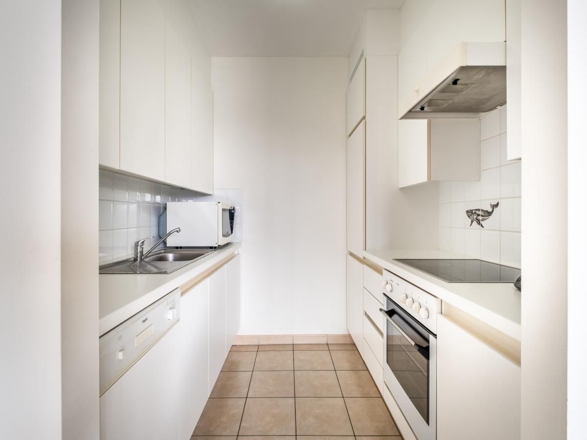 Moderne keuken in vakantiehuis Cat Tweede, Sint-Idesbald, West-Vlaanderen, met strakke witte kasten en volledige uitrusting.