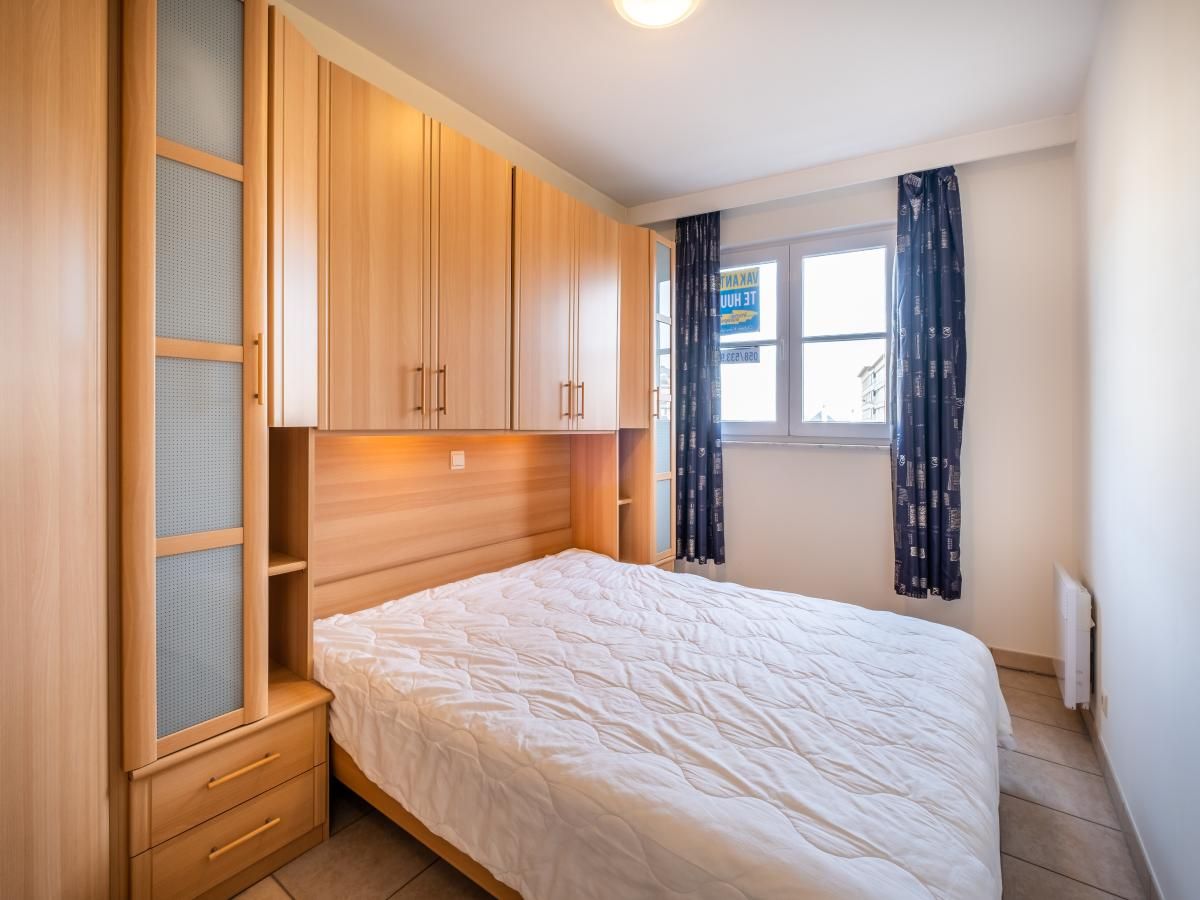 Gezellige slaapkamer in vakantiehuis Cat Tweede, Sint-Idesbald, West-Vlaanderen met houten kasten en natuurlijk licht.