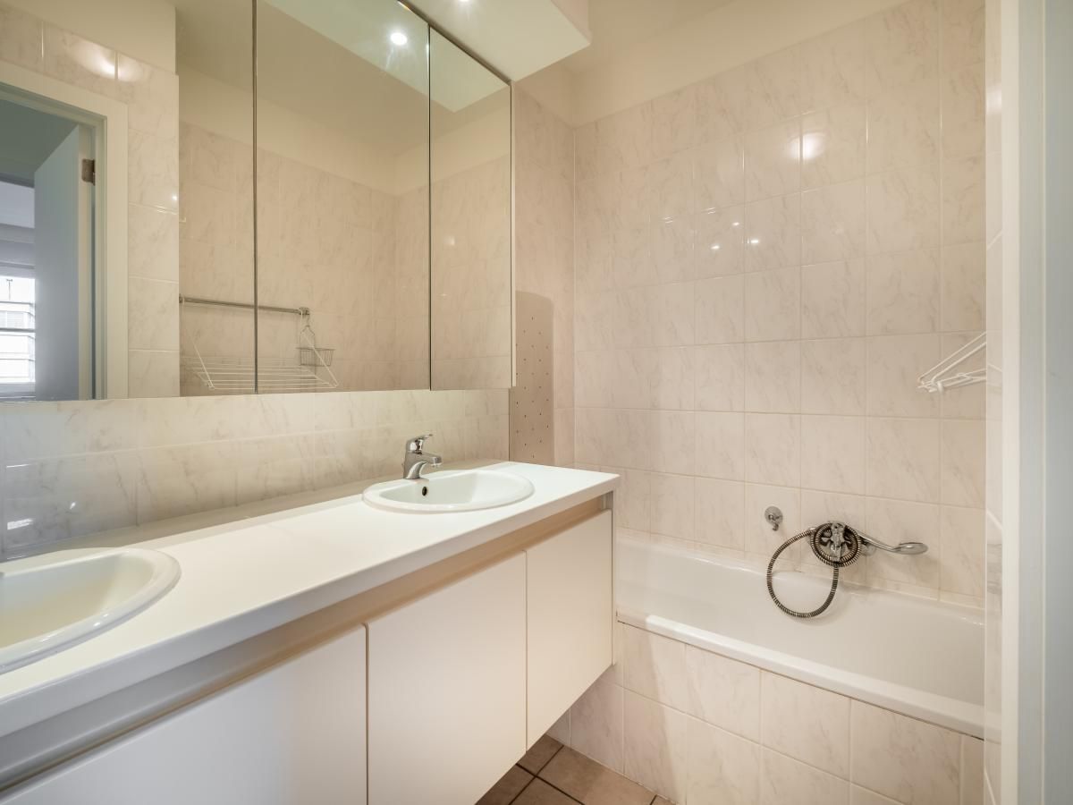 Moderne badkamer in vakantiehuis Cat Tweede, Sint-Idesbald, West-Vlaanderen met stijlvolle wastafel en ruime spiegel.