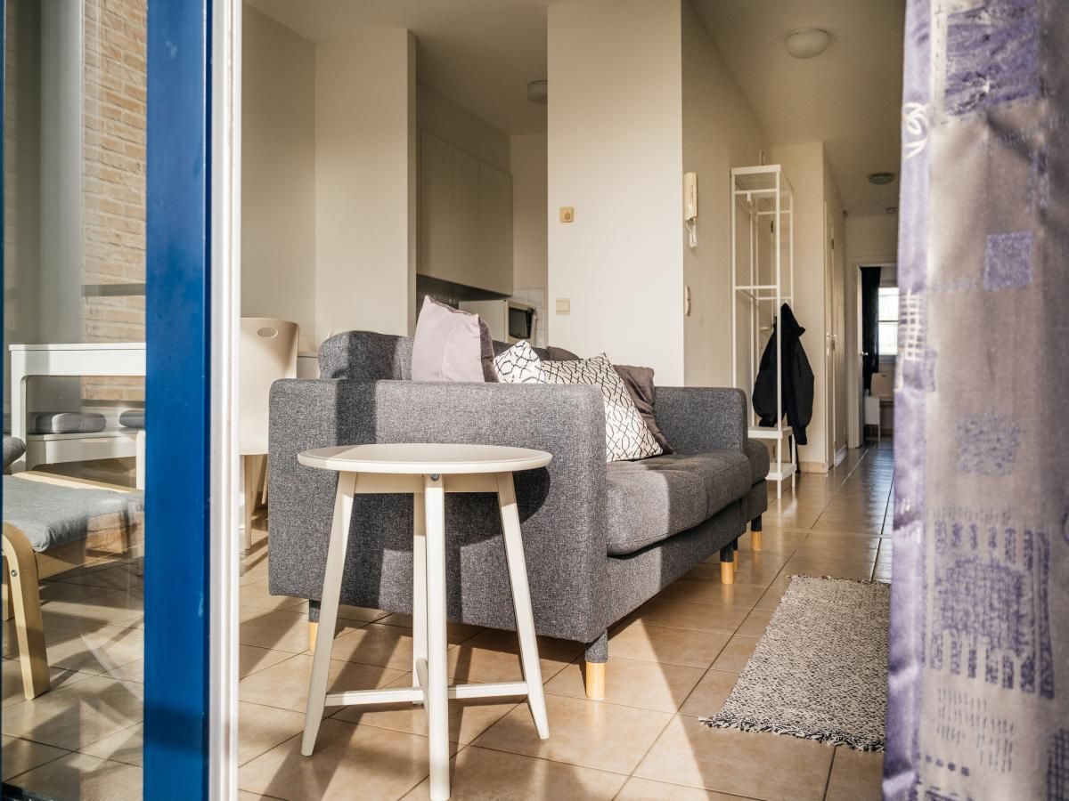 Gezellige woonkamer van vakantiehuis Cat Tweede in Sint-Idesbald, West-Vlaanderen, met comfortabele bank en moderne inrichting.