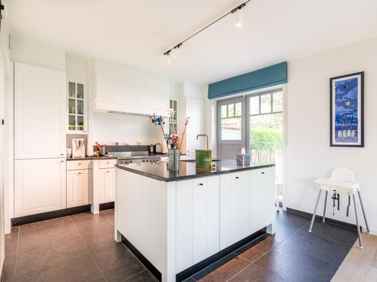 Moderne keuken in vakantiehuis La Matinee, Sint-Idesbald, West-Vlaanderen met ruime kookeiland en tuinzicht.