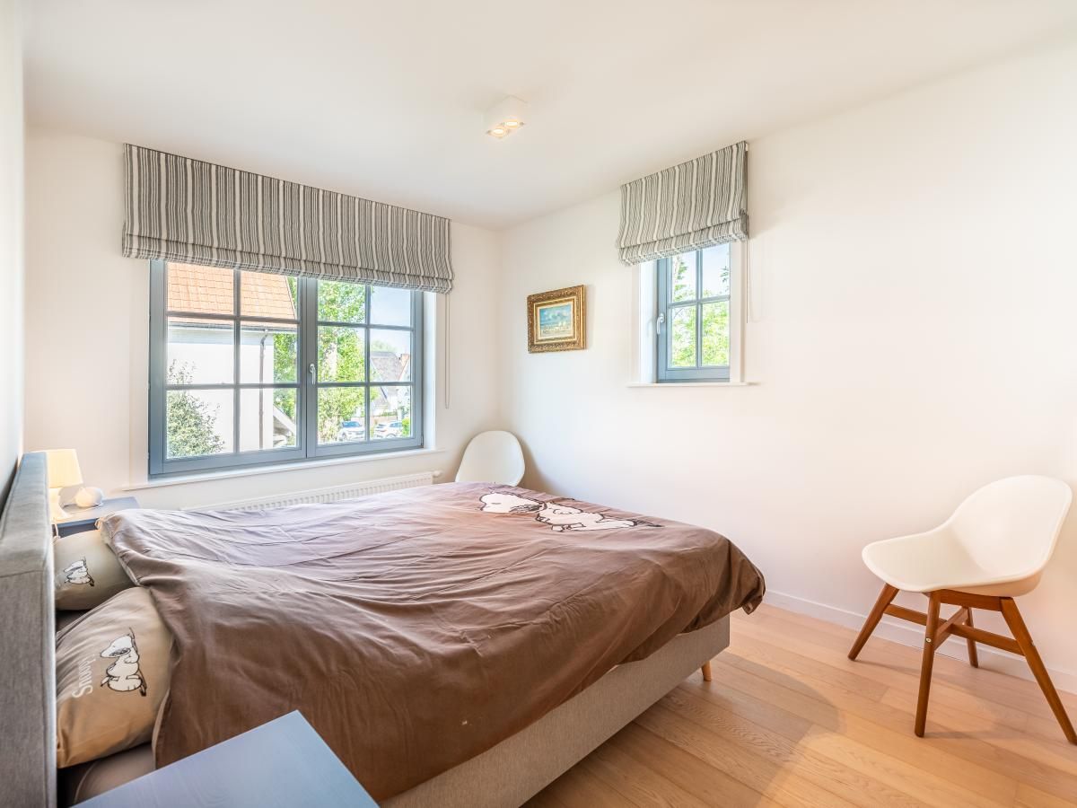 Sfeervolle slaapkamer in vakantiehuis La Matinee, Sint-Idesbald, West-Vlaanderen, met veel natuurlijk licht en moderne inrichting.