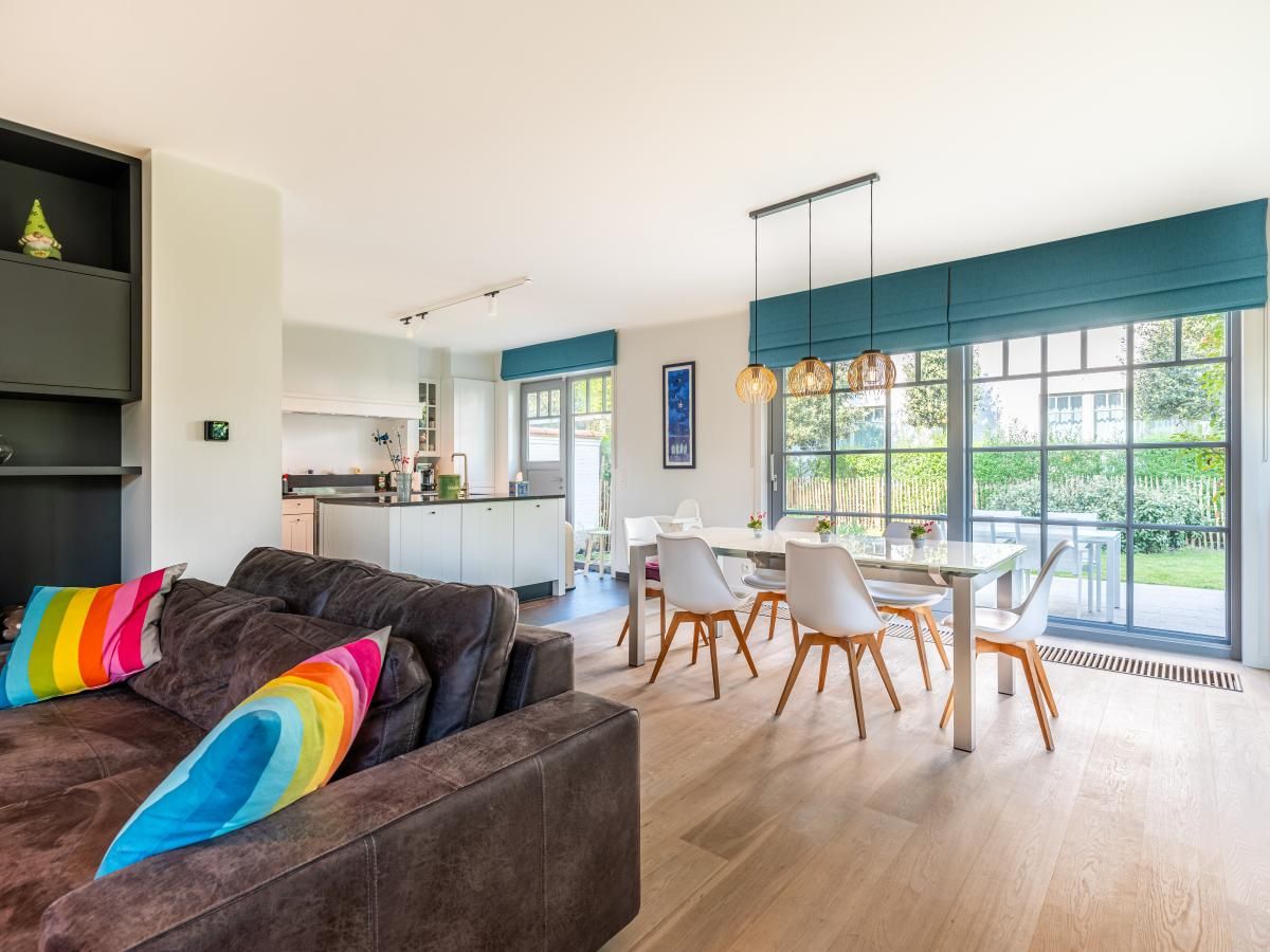 Stijlvolle woonkamer van vakantiehuis La Matinee in Sint-Idesbald, West-Vlaanderen, met moderne inrichting en uitzicht op de tuin.