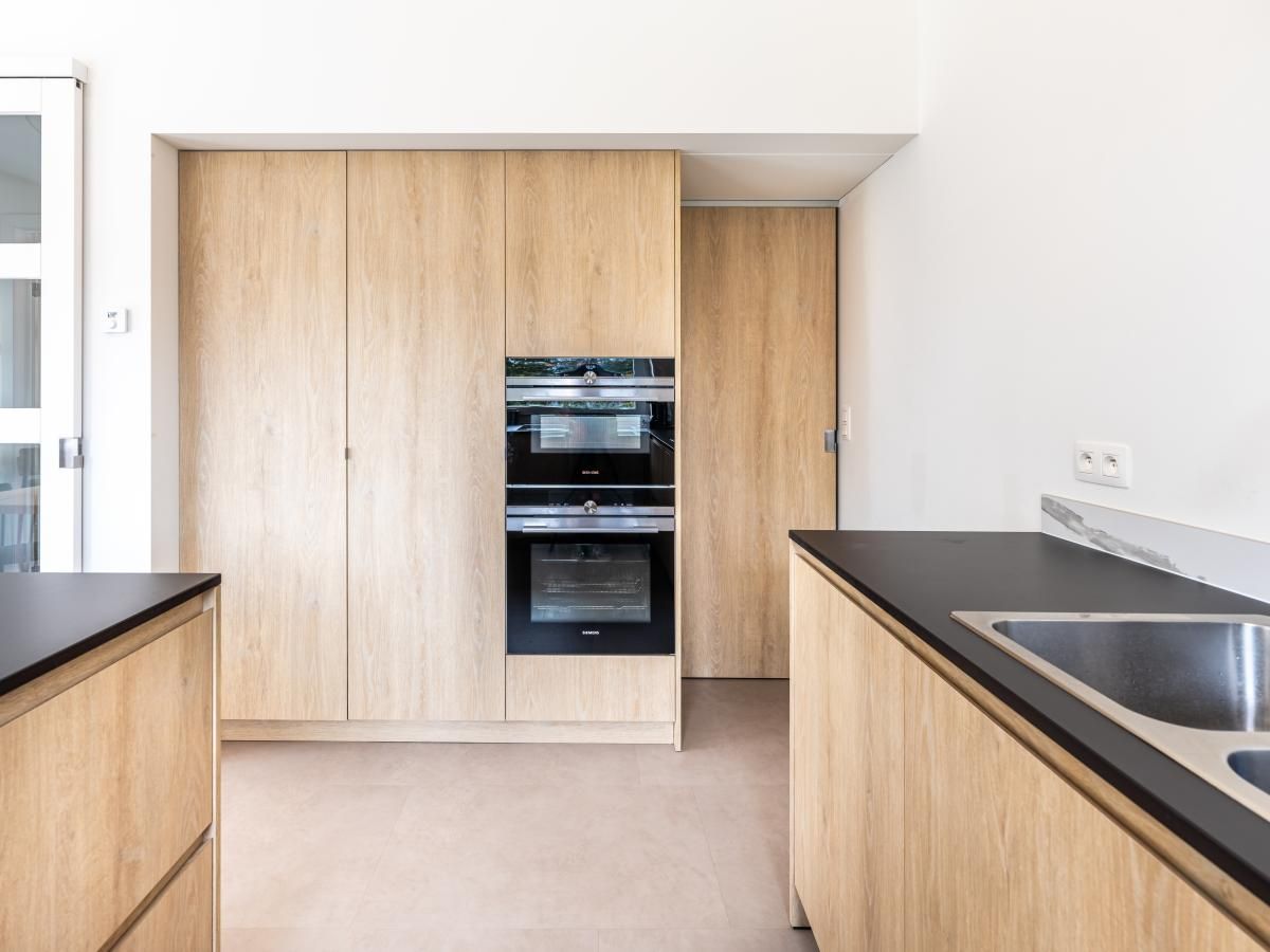 Moderne keuken in vakantiehuis La Classe, Sint-Idesbald, West-Vlaanderen. Stijlvolle houten kasten en strakke afwerking voor een comfortabel verblijf.