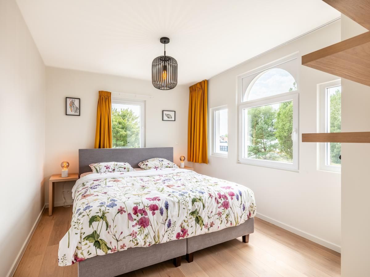 Sfeervolle slaapkamer in vakantiehuis La Classe, Sint-Idesbald, West-Vlaanderen, met lichte inrichting en uitzicht op de groene omgeving.