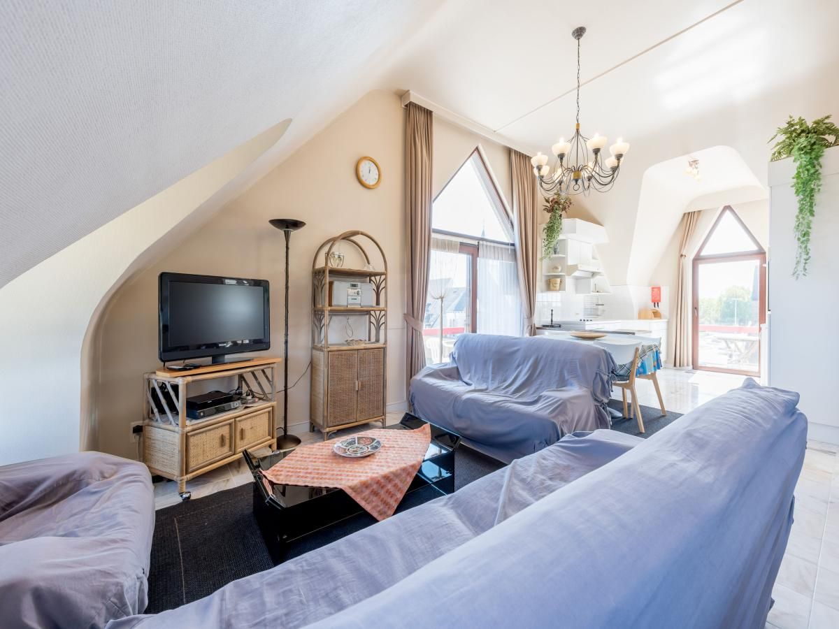 Gezellige woonkamer van vakantiehuis Aubepine troisieme in Sint-Idesbald, West-Vlaanderen, met comfortabele zithoek en veel natuurlijk licht.