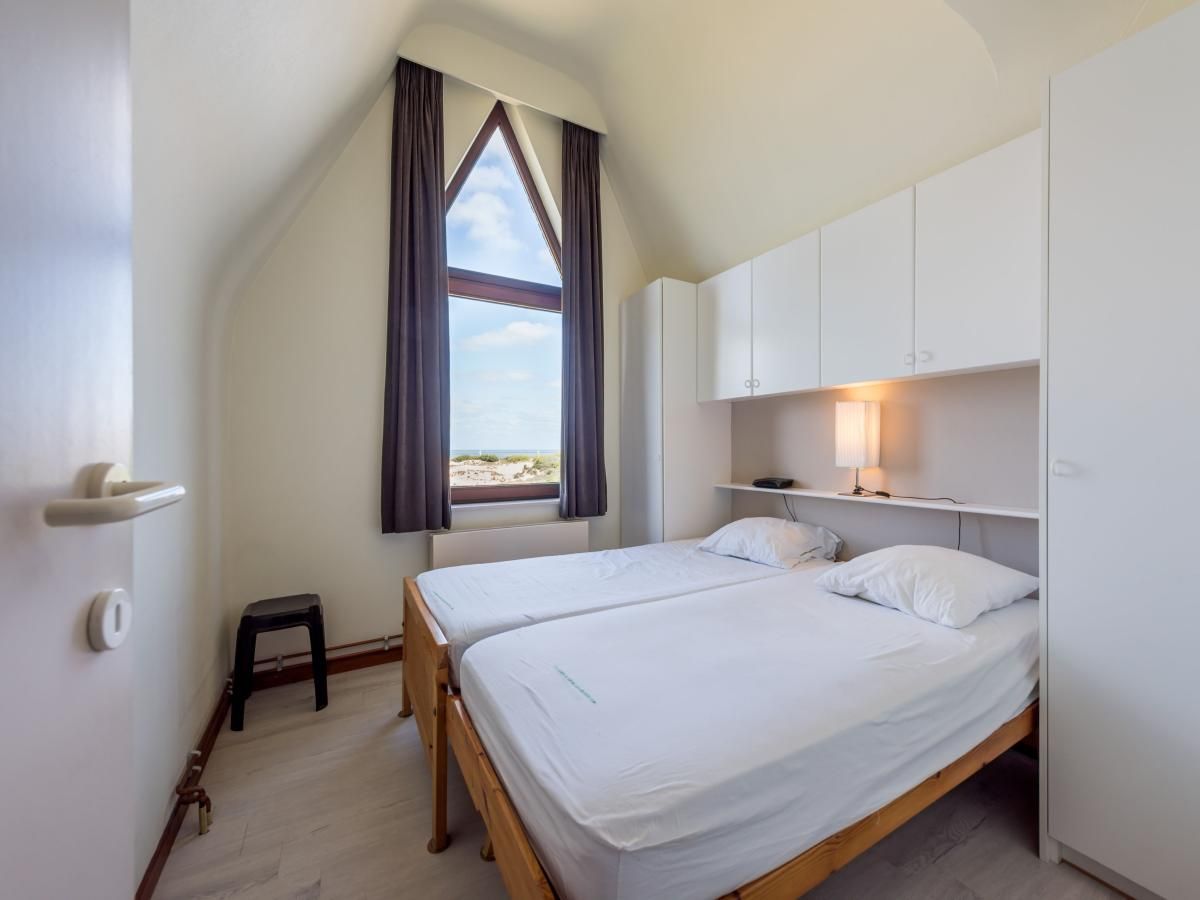Sfeervolle slaapkamer bij Aubepine troisieme in Sint-Idesbald, West-Vlaanderen, vakantiehuis met uitzicht op de kust.