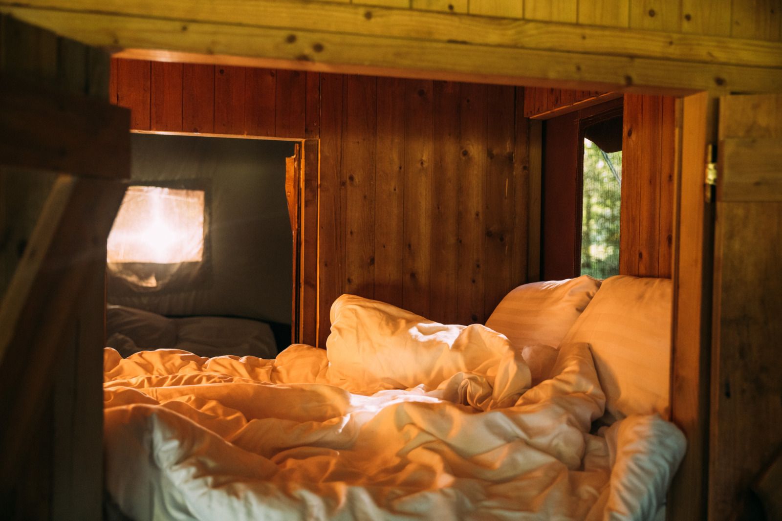 Gezellige slaapkamer in Tenthuisje met warme privedouche, Zedelgem, West-Vlaanderen. Glamping met houten interieur en knusse sfeer.