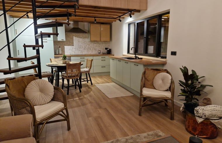 Gemuetlicher Innenraum des Ferienhauses in Ruiselede, einem Ferienhaus in Westflandern, Belgien, mit einer stimmungsvollen Kueche und Weihnachtsdekoration.