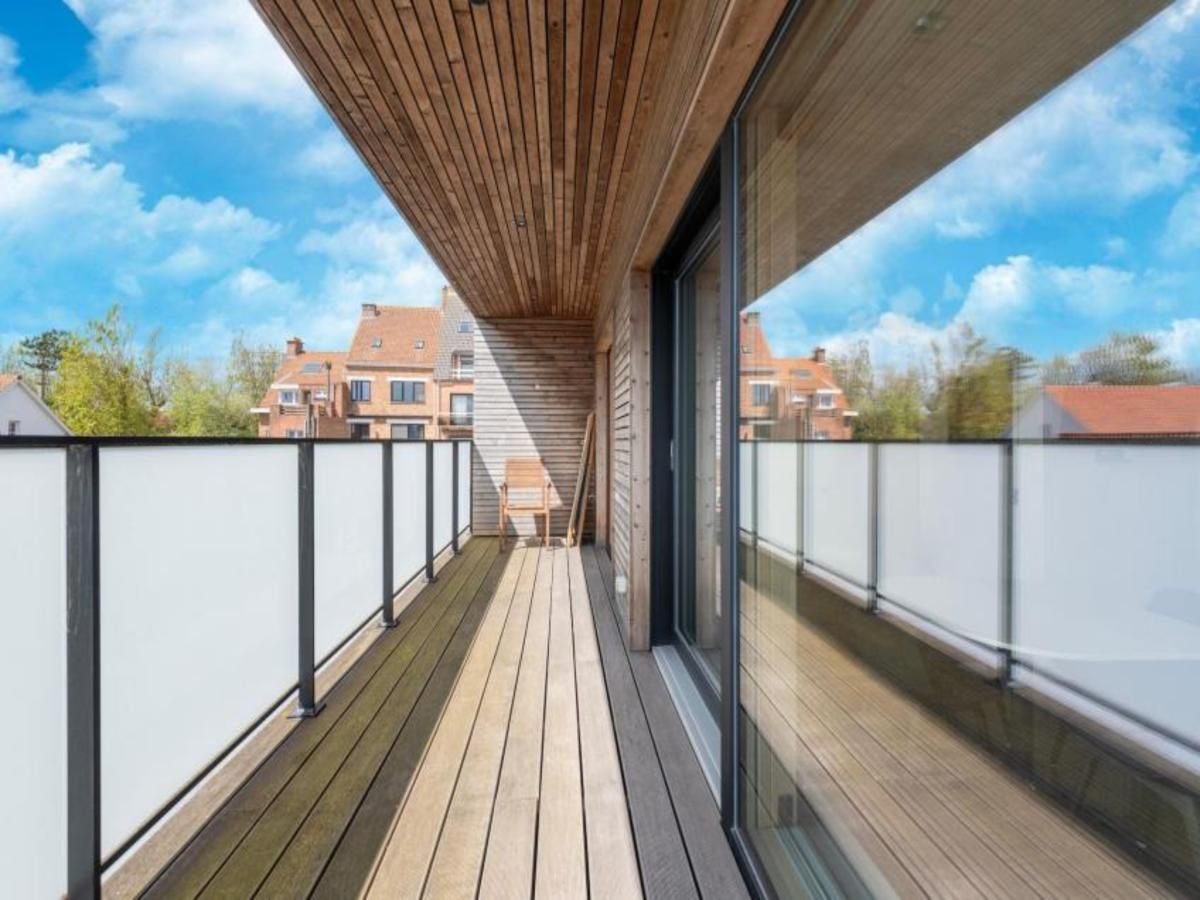 Veranda der Kruiers Eco Lodge in Middelkerke, Westflandern, mit Blick auf die Natur und moderne Architektur.