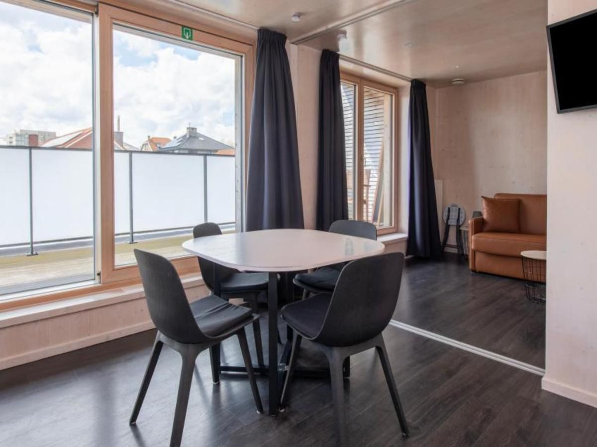 Gemuetlicher Innenbereich der Kruiers Eco Lodge in Middelkerke, Westflandern, mit einem modernen Essbereich und grossen Fenstern fuer viel natuerliches Licht.