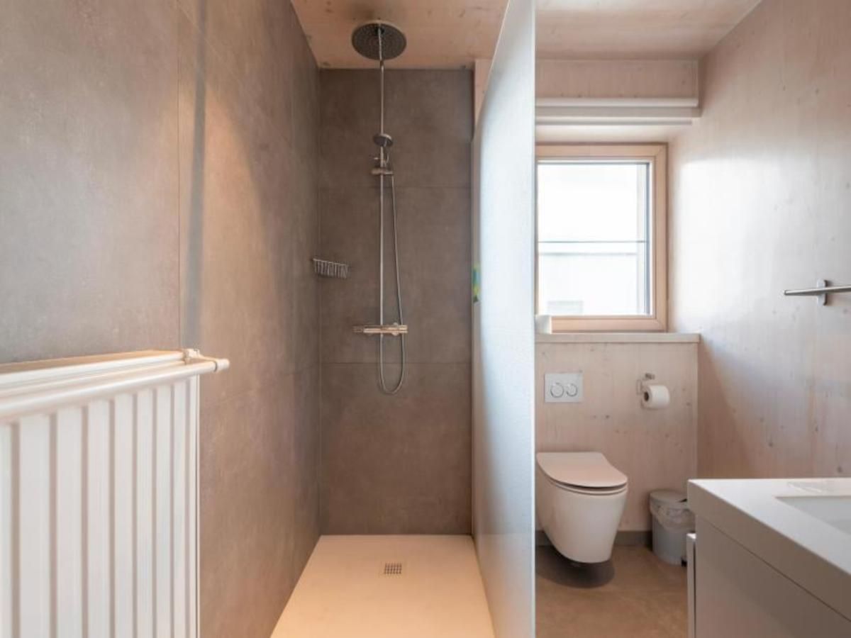 Modernes Badezimmer in Kruiers Eco Lodge, einem Ferienhaus in Middelkerke, Westflandern, mit geraeumiger Dusche und natuerlichem Licht.