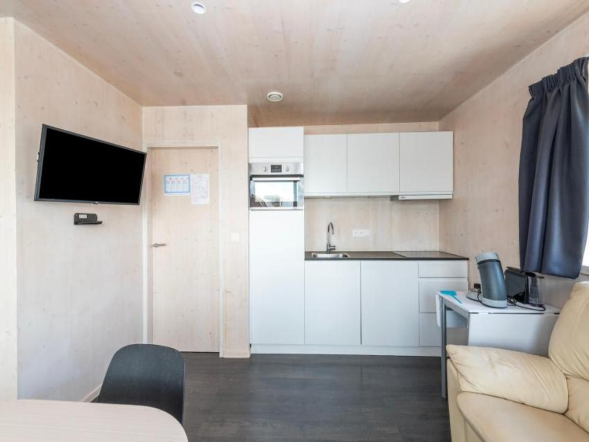 Modernes Interieur der Kruiers Eco Lodge, eines Ferienhauses in Middelkerke, Westflandern, mit eleganter Kueche und komfortabler Sitzecke.