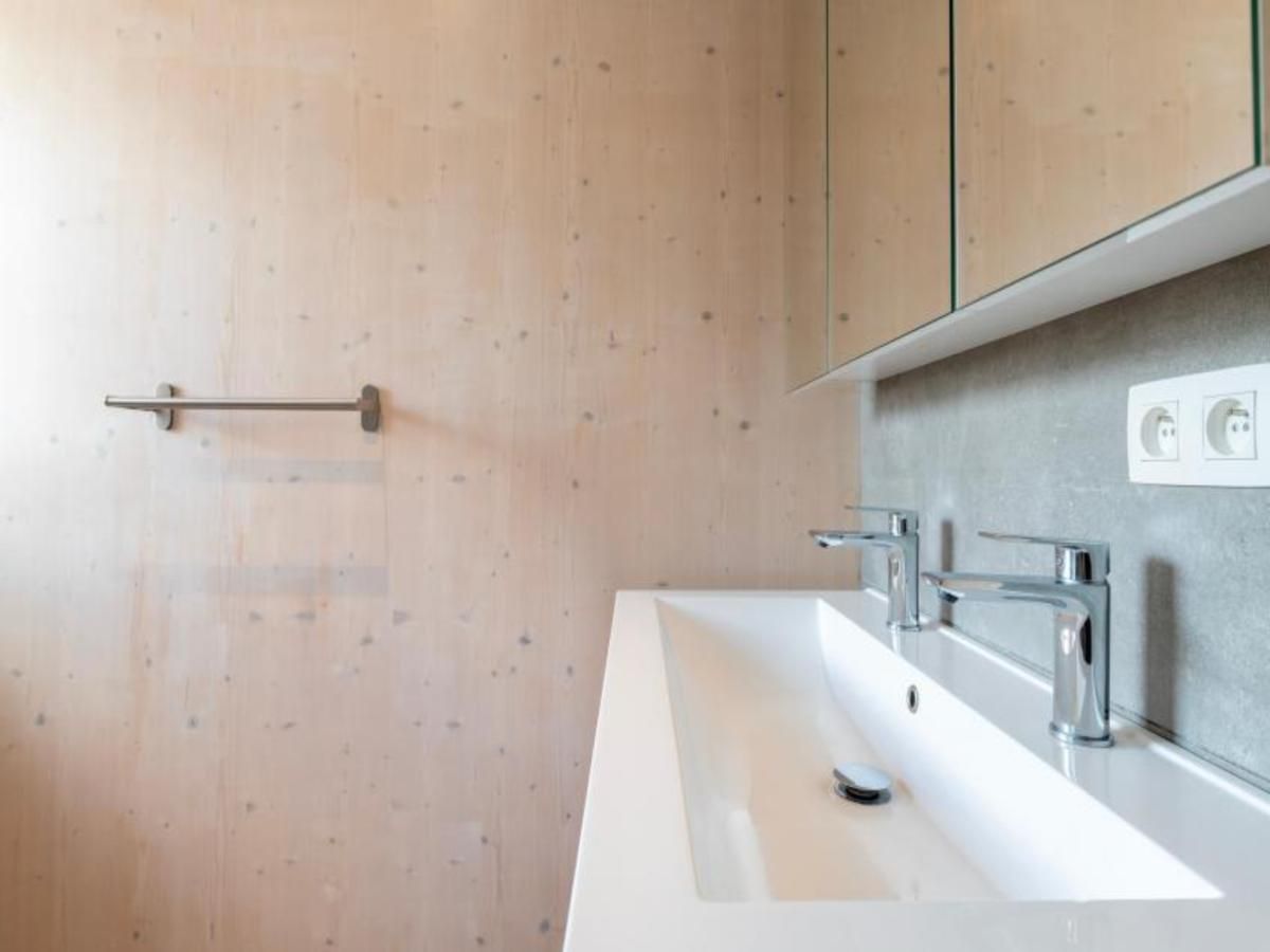 Modernes Badezimmer in der Kruiers Eco Lodge, einem Ferienhaus in Middelkerke, Westflandern, mit stilvollem Waschbecken und Spiegelschrank.