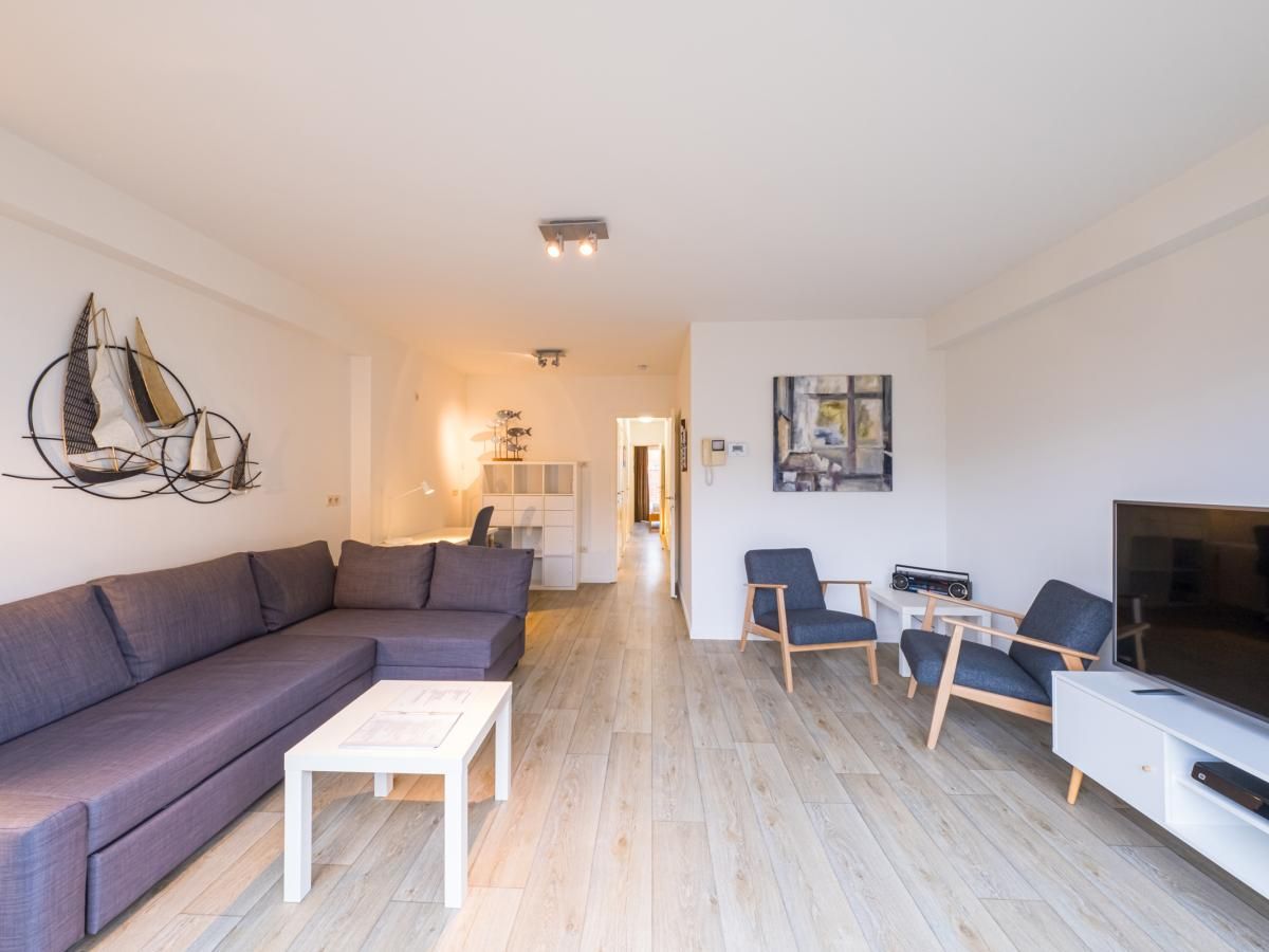 Geraeumiges Wohnzimmer im Ferienhaus Scholekster - 0004 in Middelkerke, Westflandern, mit gemuetlicher Sitzecke und moderner Einrichtung.