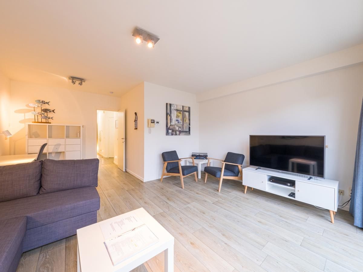 Modernes Wohnzimmer im Ferienhaus Scholekster - 0004 in Middelkerke, Westflandern, mit gemuetlicher Sitzecke und Flachbildfernseher.