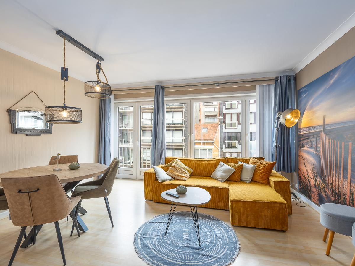 Gemuetliches Wohnzimmer des Ferienhauses Wimbledon D - 0205 in Middelkerke, Westflandern, mit einer bequemen Sitzecke und viel Tageslicht.