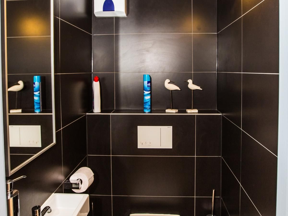 Modernes Badezimmer im Ferienhaus Michelangelo - 0605, Middelkerke, Westflandern, mit stilvollen schwarzen Fliesen und dekorativen Elementen.