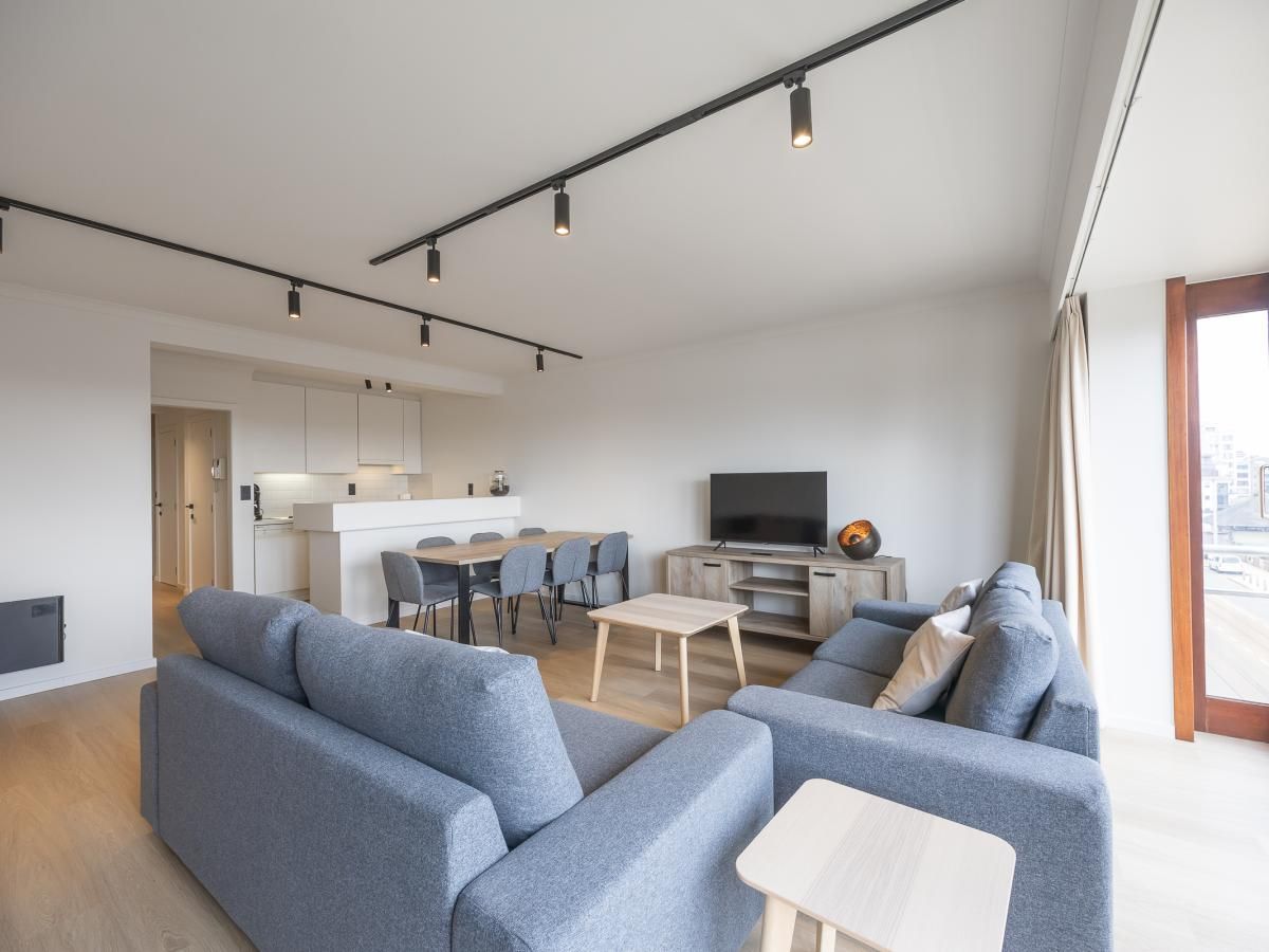 Geraeumiges Wohnzimmer des Ferienhauses "Harmony - 0301" in Middelkerke, Westflandern, mit moderner Einrichtung und Blick auf die Terrasse.