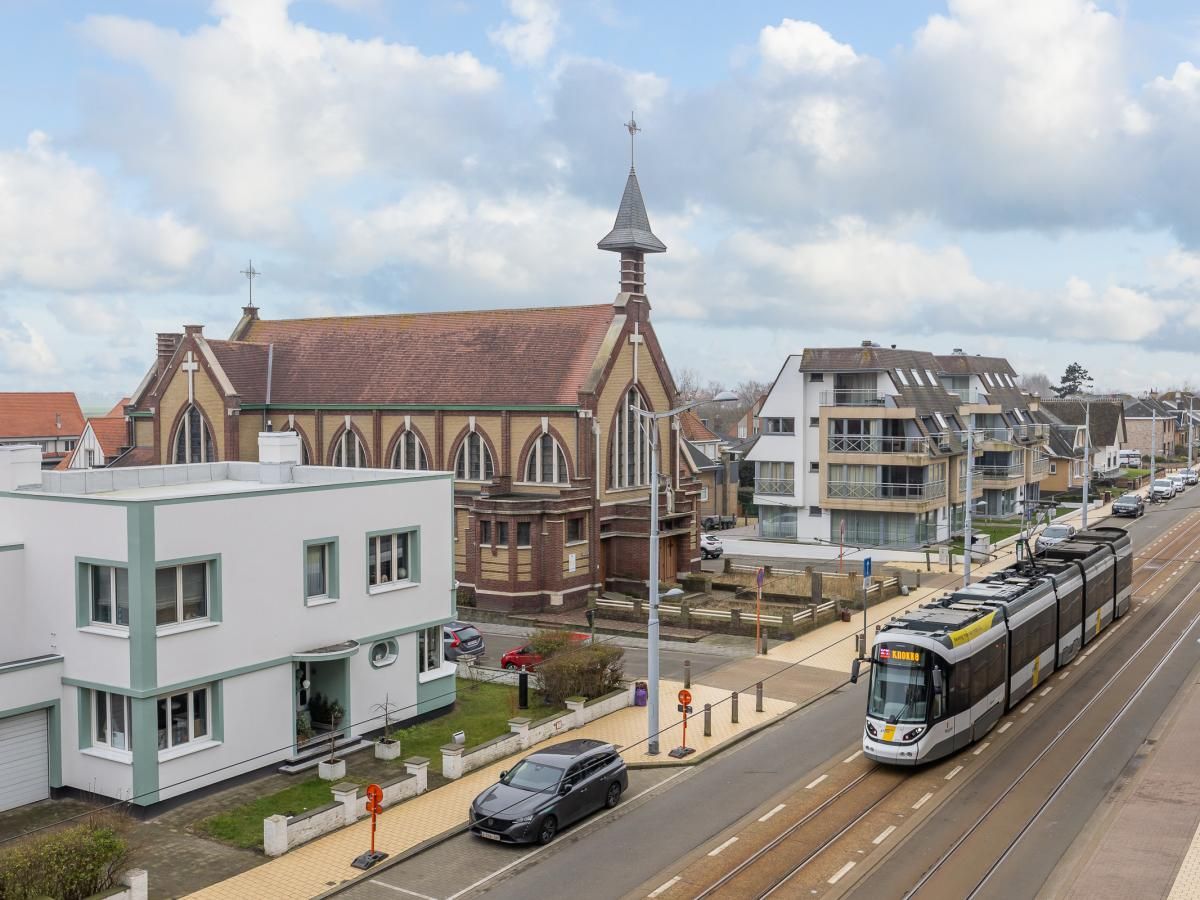 Blick vom Ferienhaus "Harmony - 0301" in Middelkerke, Westflandern, mit der Kirche und der Kuestenstrassenbahn in der Strasse.